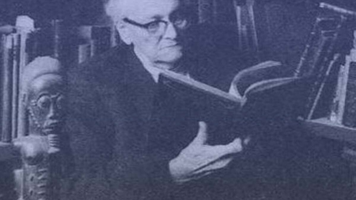 Manly P. Hall portrait reading in a library
